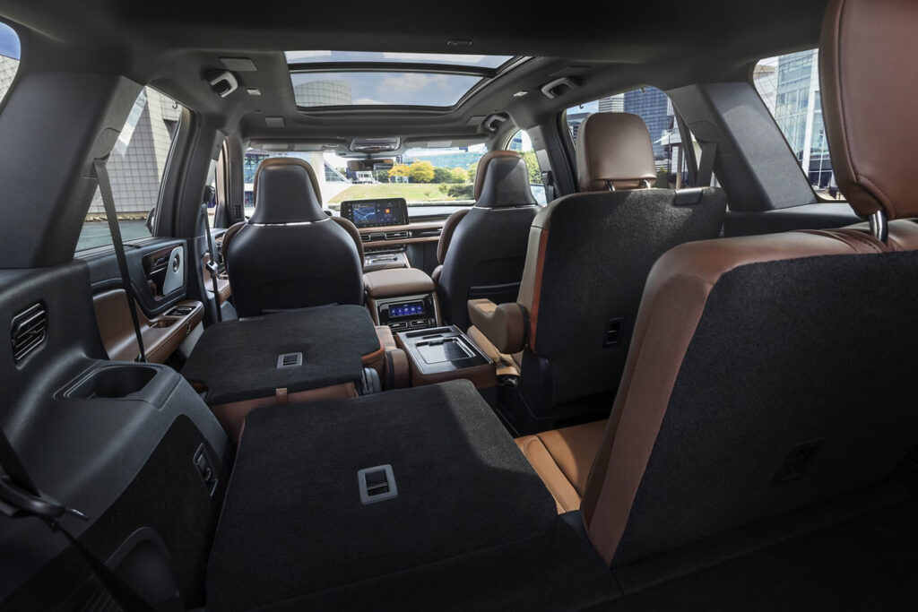 Spacious SUV interior with folded rear seats, panoramic sunroof, and modern dashboard.